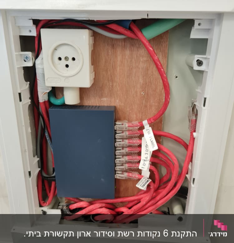 ארון תקשורת עם כבלים אדומים ומחבר חשמלי